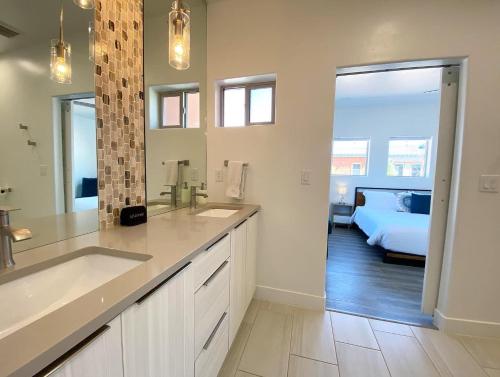 a bathroom with a sink and a bed in a room at Timber & Tin D 2Bed 2Bath w Pool & Rooftop Deck in Kanab
