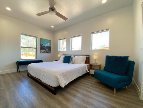 a bedroom with a bed and a blue chair at Timber & Tin D 2Bed 2Bath w Pool & Rooftop Deck in Kanab