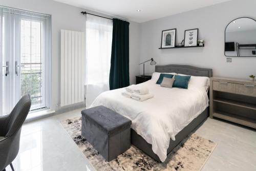 a bedroom with a large bed and a window at Canary Wharf O2 Deluxe Ensuite Rooms in London