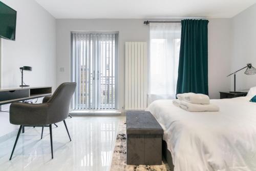 a bedroom with a bed and a desk and a chair at Canary Wharf O2 Deluxe Ensuite Rooms in London