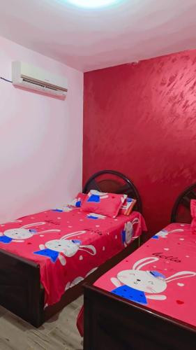 Marina Delta في Al Ḩammād: غرفة نوم مع سريرين مع ملاءات قطة ترحيبية