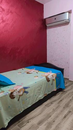a bedroom with a bed in a pink wall at Marina Delta in Al Ḩammād