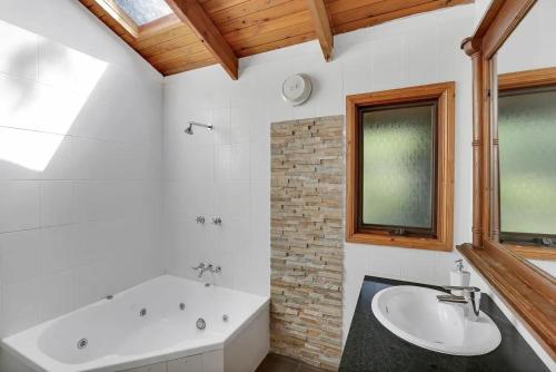 un bagno con vasca e lavandino di Canyon Cottage Majestic view a Blackheath