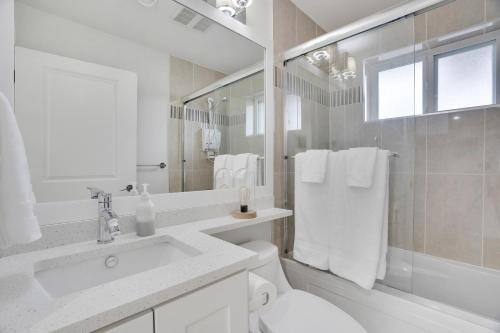 Baño blanco con lavabo y aseo en Family-Friendly, 3 Bed House - Private Backyard-Central Location en Vancouver