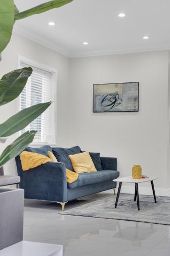 a living room with a blue couch and a table at Family-Friendly, 3 Bed House - Private Backyard-Central Location in Vancouver