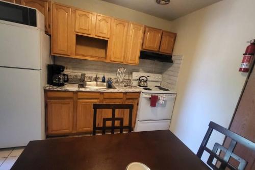 a kitchen with wooden cabinets and a table and a refrigerator at Entire Apt in Chester 