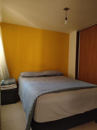 1 dormitorio con 1 cama con pared amarilla en Comodo Practico Ubicado, en Ciudad de México