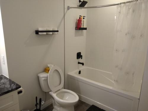 a white bathroom with a toilet and a shower at Comfy Condo Near Downtown in Kitchener