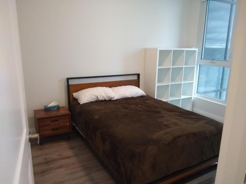 a bedroom with a bed and a dresser and a window at Comfy Condo Near Downtown in Kitchener