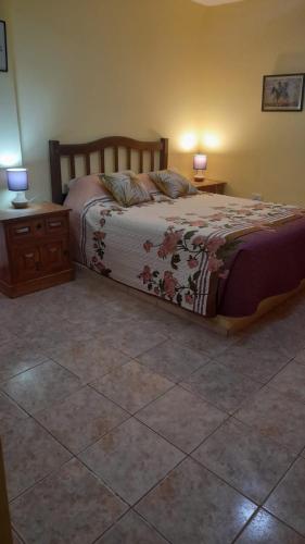 a bedroom with a bed and two night stands and two lamps at La Normita cabañas in Potrerillos