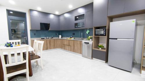 a kitchen with a refrigerator and a table and chairs at Marki Home in Ho Chi Minh City
