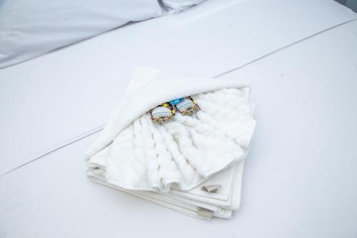 una bolsa blanca con dos anillos en una cama en Flat - Mini House, en Lagoa Santa