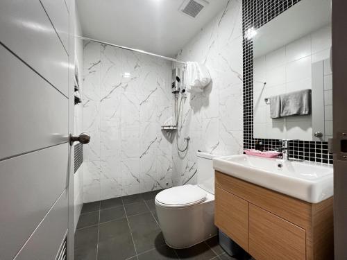 a white bathroom with a toilet and a sink at Smile Residence at Kaset-Sena in Ban Yang