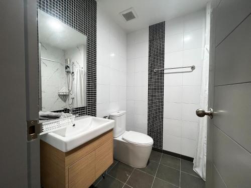 a white bathroom with a sink and a toilet at Smile Residence at Kaset-Sena in Ban Yang