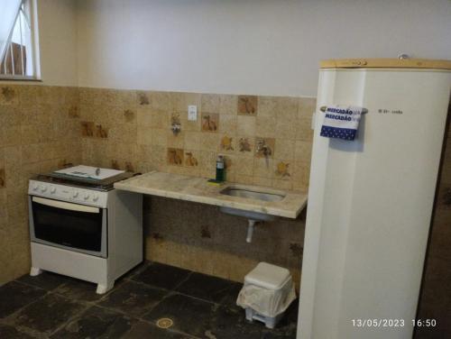 eine kleine Küche mit Spüle und Kühlschrank in der Unterkunft Andres home casa J in Governador Valadares