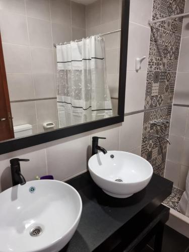 Baño con 2 lavabos y espejo en HOSTERIA CAROL en Salta