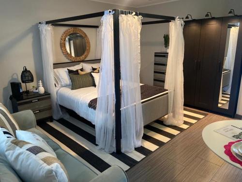sypialnia z łóżkiem z zasłonami i lustrem w obiekcie Tropical Oasis by the beach and shops, with pool w mieście Riviera Beach
