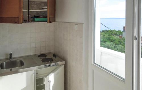 a kitchen with a sink and a window at Pet Friendly Apartment In Martinscica With Kitchen in Martinšćica
