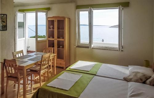 a bedroom with a bed and a table with a view of the ocean at Pet Friendly Apartment In Martinscica With Kitchen in Martinšćica