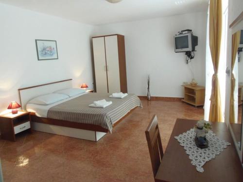 um quarto com uma cama, uma mesa e uma televisão em Apartment in Dramalj with sea view, balcony, air conditioning, WiFi 4623-6 em Dramalj