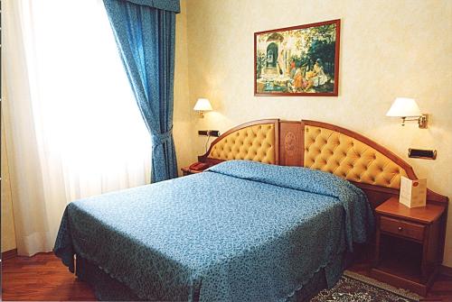 a hotel room with a bed and two lamps at Hotel Antico Masetto in Lamporecchio