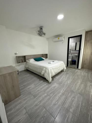 um quarto com uma cama e piso em madeira em Hotel Plataneras Caney em Turbo