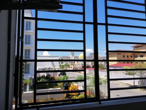 uma vista para uma cidade a partir de uma janela com persianas em Sis Homestay Wakaf Che Yeh, Kota Bharu em Kota Bharu