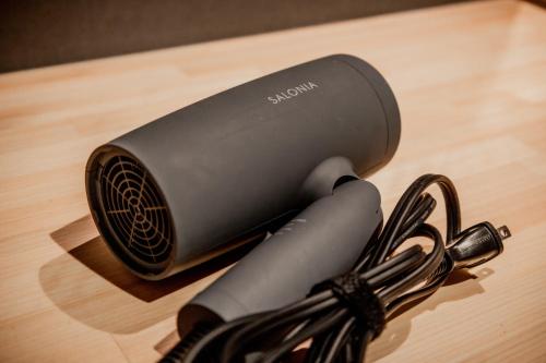 a cord plugged into a device on a wooden table at Solabase in Kazo