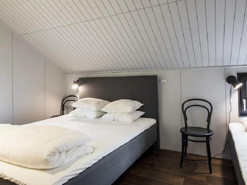 a bedroom with a large bed and a chair at Holiday home SÄLEN II in Stöten