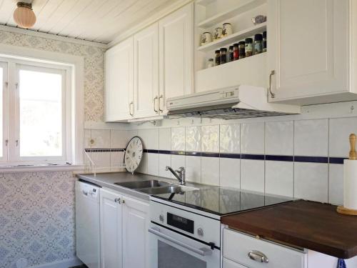 a kitchen with white cabinets and a sink and a window at 4 person holiday home in GRUNDSUND in Grundsund