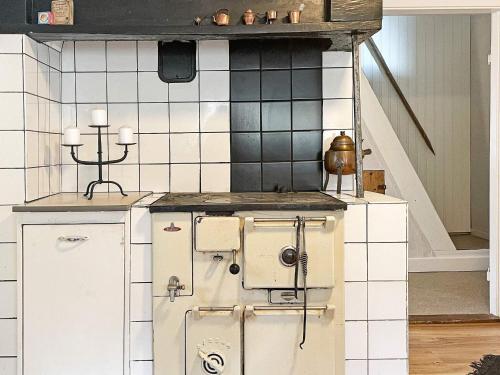 una vecchia stufa in una cucina con parete piastrellata di Holiday home Hestra a Hestra