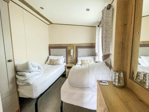 a room with two beds and a mirror at Modern Caravan With Large Decking Area And Wifi, Ref 60057ch in Saxmundham