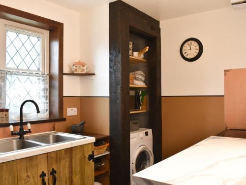 a kitchen with a sink and a washing machine at Primrose Cottage in Elgin