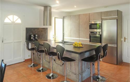 una cucina con isola e sgabelli neri da bar di Cozy Home In Salles D'aude With Wifi a Salles-d'Aude