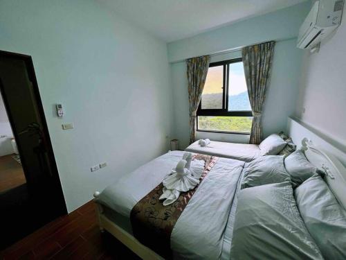 a bedroom with a large bed with a window at 林莊園包棟別墅Skydoorzi Villa in Guoxing