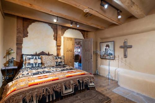 een slaapkamer met een bed en een kruis aan de muur bij Casita Mariposa in Santa Fe