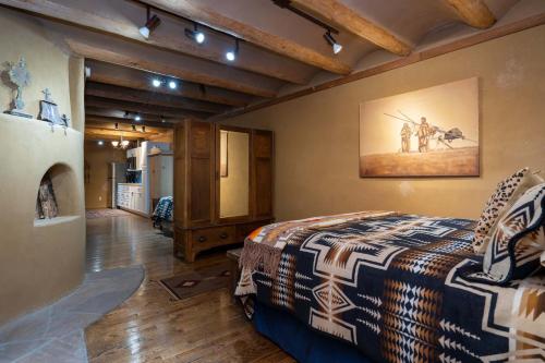 a bedroom with a bed and a painting on the wall at Casita Mariposa in Santa Fe