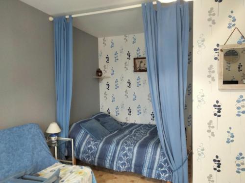 - une chambre avec un lit et des rideaux bleus dans l'établissement Studio cosy au cœur du Marché Arago, à 400 m de la grande plage, avec balcon et local vélos - FR-1-331-224, à Les Sables-dʼOlonne