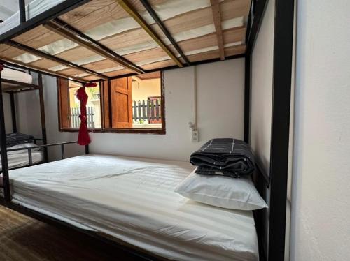 Una cama grande con una bolsa encima. en Aurora Backpackers Hostel, en Luang Prabang