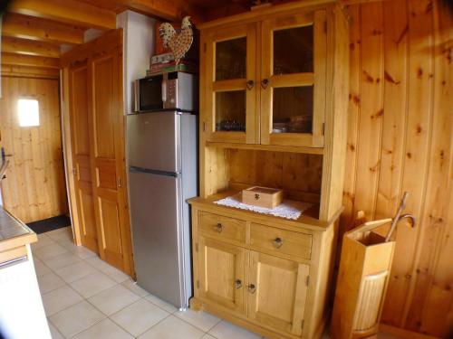 La cuisine est équipée d'un réfrigérateur et de placards en bois. dans l'établissement Duplex confortable, proche base de loisirs & remontées, animaux acceptés, parking - FR-1-629-125, à Morillon