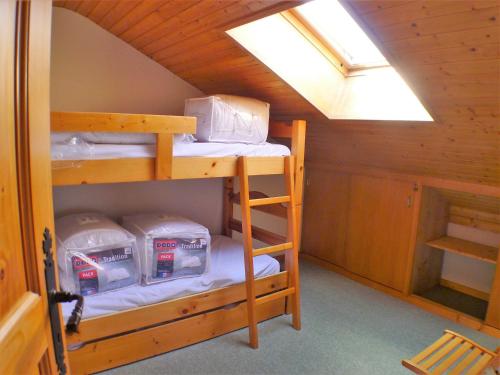 Cette chambre mansardée comprend des lits superposés et une lucarne. dans l'établissement Duplex confortable, proche base de loisirs & remontées, animaux acceptés, parking - FR-1-629-125, à Morillon