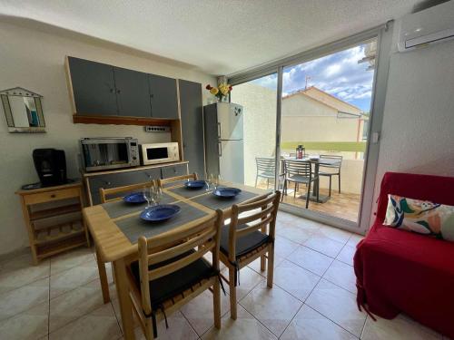 une cuisine avec une table et des chaises et une cuisine avec vue dans l'établissement Appartement 2P climatisé avec terrasse, parking et wifi à St-Cyprien, proche plage - FR-1-225D-182, à Saint-Cyprien