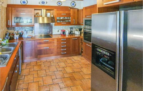 a kitchen with wooden cabinets and a stainless steel refrigerator at Pet Friendly Home In Kiato With Sauna in Kiáton