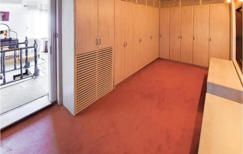 a room with wooden cabinets and a red floor at Pet Friendly Home In Kiato With Sauna in Kiáton