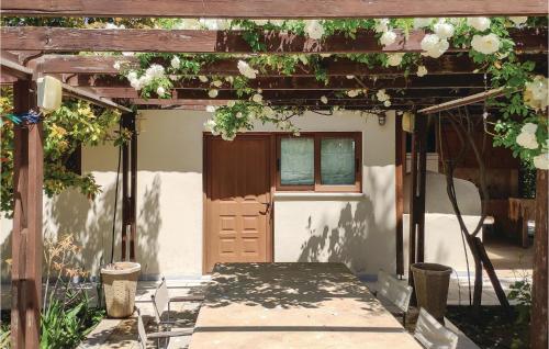 a pergola with a door and flowers on it at Pet Friendly Home In Kiato With Sauna in Kiáton