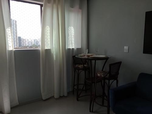 a room with a table and chairs and a window at Apt na Torre - Recife in Recife