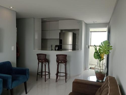 a living room with a couch and two stools at Apt na Torre - Recife in Recife