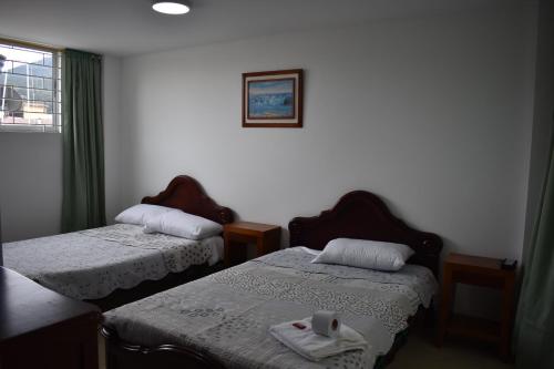 a room with two beds and a window at Dorado Plaza in Zipaquirá