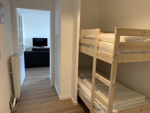 une chambre avec des lits superposés et une chambre avec un couloir dans l'établissement Appartement Neuf Centre-Ville Fort-Mahon-Plage avec Balcon et Parking, Idéal Famille - FR-1-482-114, à Fort-Mahon-Plage