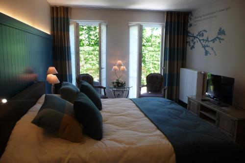 a bedroom with a large bed and a television at B&B Riche Terre in Damme